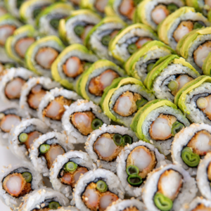 Un rollo de sushi con kanikam, queso crema y palta. El kanikam es blanco y crujiente, el queso crema es blanco y cremoso, la palta es verde y cremosa.