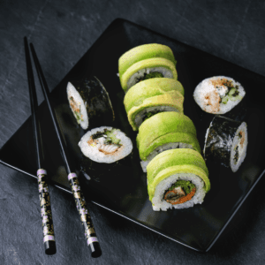 Un rollo de sushi con salmón y palta. El salmón es rosado y brillante, y la palta es verde y cremosa.