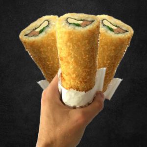 Una imagen de un Hand Roll de Kanikama + Queso Crema + Cebollín, envuelto en alga nori y panko crujiente. El kanikama es rosado y crujiente, el queso crema es blanco y cremoso, y el cebollín es verde y fresco. El alga nori es de color verde oscuro y el panko crujiente es de color dorado.