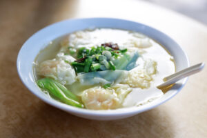 Sopa de Wantán tradicional china, servida con caldo de verduras ,carne pollo tallarines chino hojas de wantán y cebollín